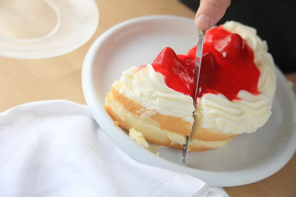 Cutting a slice of fruit-glazed cake — Stock Photo, Image