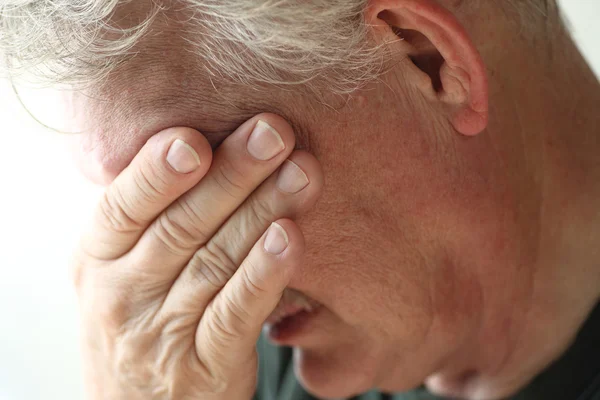 Człowiek obejmuje twarz ręką — Stockfoto