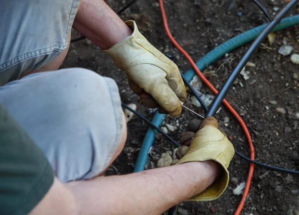 Mann installiert Sprinkleranlage in Hinterhof — Stockfoto