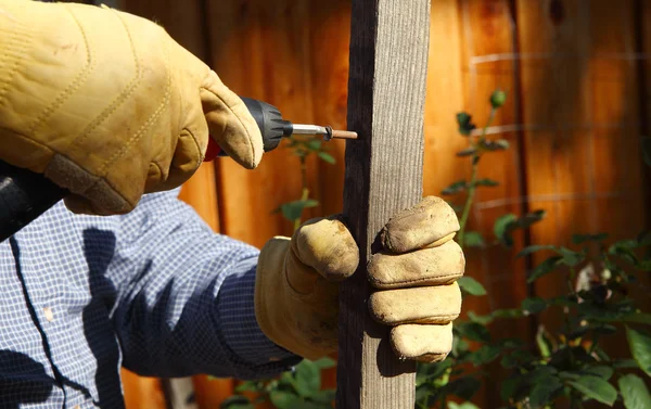 Hombre taladra en un pedazo de madera —  Fotos de Stock