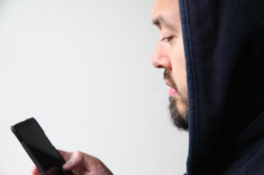 Cep telefonu ile kapüşonlu genç adam