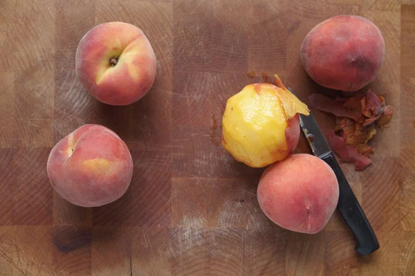 Ripe summer peaches, one peeled — Stock Photo, Image