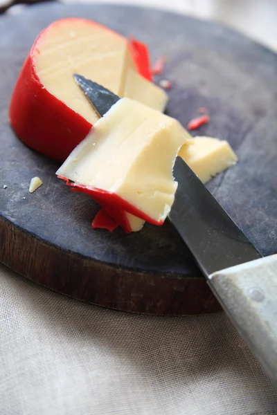 Cortando uma cunha de queijo Gouda — Fotografia de Stock