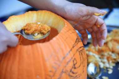 Man pulls seeds from Halloween pumpkin clipart