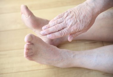 Adam otururken ayak dokunmak çalışır