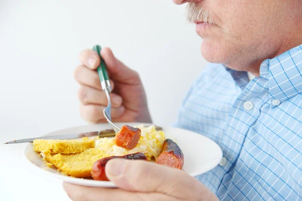 ソーセージと卵の朝食と年上の男 — ストック写真