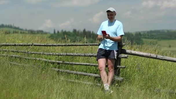 Людина з мобільним телефоном у полі — стокове відео