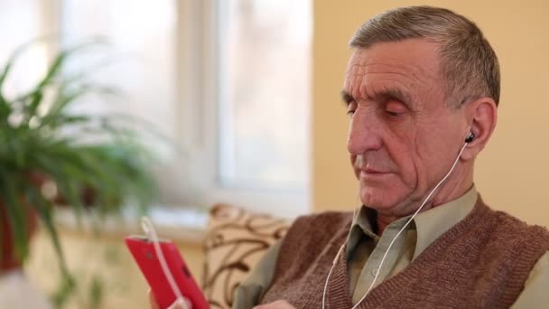 Senior man communiceert via smartphone — Stockvideo