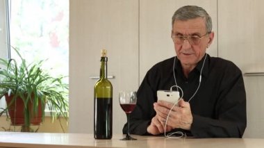 Adam cep telefonu ile tablo ve İçecek şarap oturur