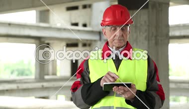 Müdürü inşaat sahasında elektronik cihaz ile çalışır