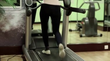 Spor salonunda treadmill üzerinde yürüyen kadın