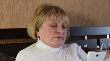 Kadın kıdemli koltukta oturur ve müzik dinliyor