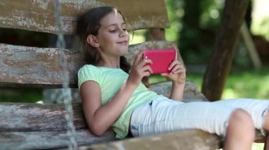 Kız kırmızı smartphone ile oturur ve müzik dinliyor