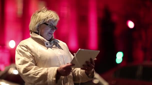 Vezető nő az út mellett áll, és kommunikál keresztül tabletta számítógép — Stock videók