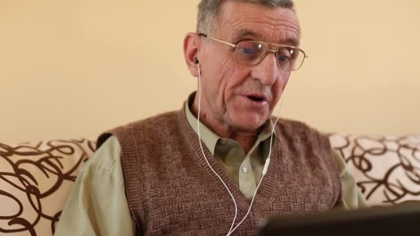 Hombre mayor se comunica a través de ordenador portátil — Vídeos de Stock