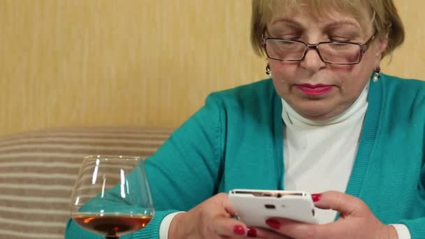 Женщина со смартфоном говорит и курит — стоковое видео