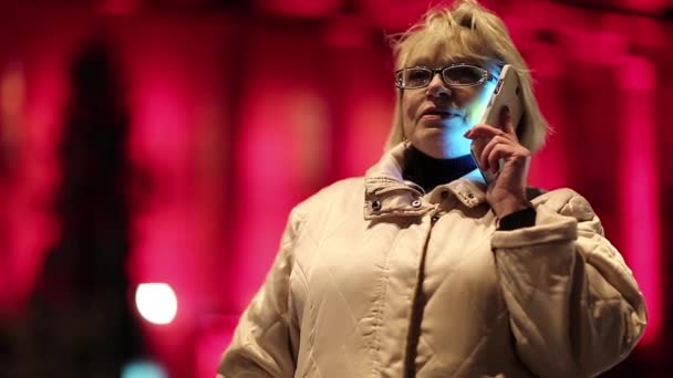 Senior woman with cell phone stands near the road — Stock Video