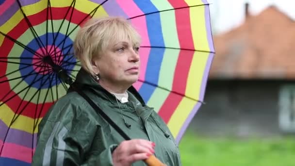 Senior woman with colorful umbrella — Stock Video