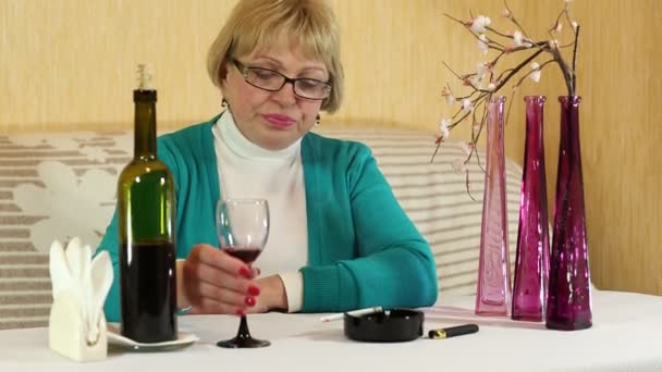 Kadın şarap içiyor ve bir sigara içiyor — Stok video