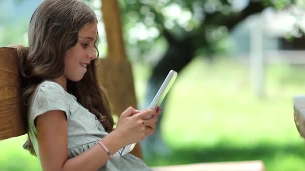 Dívka si hraje hru na svém počítači tablet — Stock video
