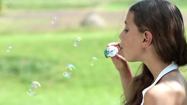 Attractive girl blowing soap bubbles — Stock Video