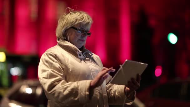 Businesswoman with glasses stands near the road and uses Tablet PC — Stock Video