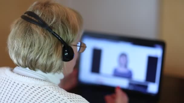 Vrouw met hoofdtelefoon op computer gesprekken — Stockvideo