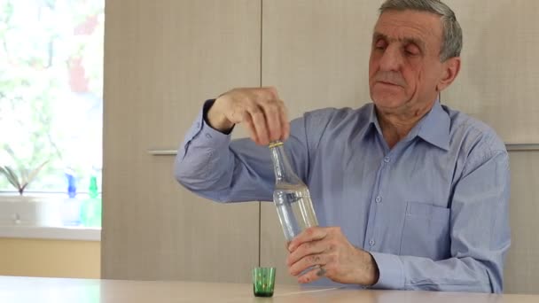 L'homme s'assoit à la table et boit de la vodka — Video