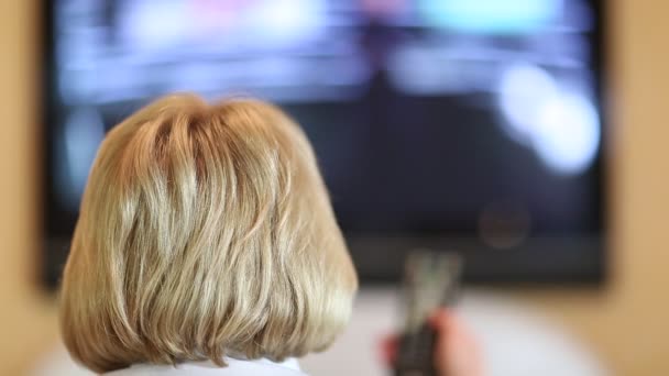 Žena s dálkovým ovládáním přepínání televizních kanálů — Stock video