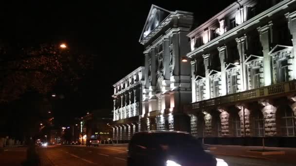 Carros perto do edifício com iluminação noturna — Vídeo de Stock