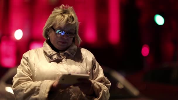 Senior woman with smartphone in nighttime — Stock Video