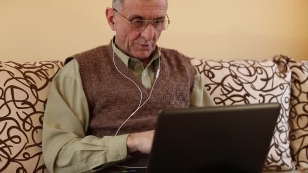 Hombre mayor se comunica a través de ordenador portátil — Vídeo de stock