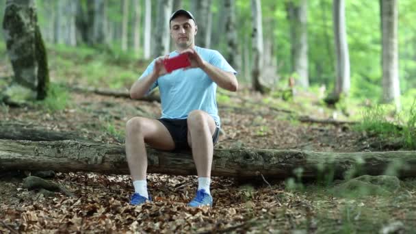 Az ember leül egy kidőlt fát, és teszi a képek — Stock videók
