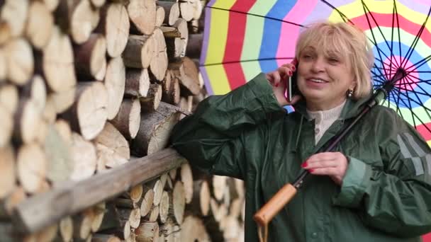 Mujer rubia con paraguas multicolor — Vídeos de Stock
