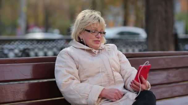 Старшая женщина со смартфоном — стоковое видео