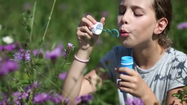 Girl blowing soap bubbles. — Stock Video