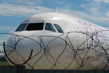 KYIV, UKRAINE, 27 Temmuz 2020: Covid-19 salgını sırasında çalışmayan, Igor Sikorsky Kyiv Uluslararası Havalimanı 'ndaki Wizz Air uçağının dikenli telleriyle çitin arkasından görüntüle