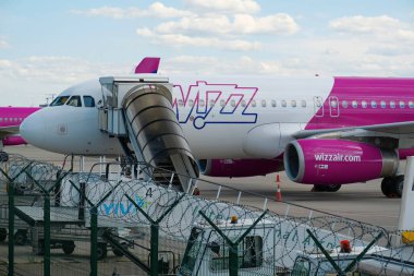 UKRAINE, KYIV, 21 Temmuz 2020: Covid-19 salgını sırasında çalışmayan, Igor Sikorsky Kyiv Uluslararası Havalimanı 'ndaki Wizz Air uçağının dikenli telleri ile çitin arkasından görünüm