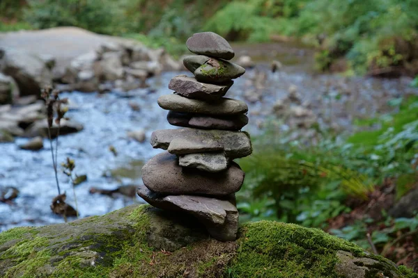 Pyramid of stones near beautiful small river