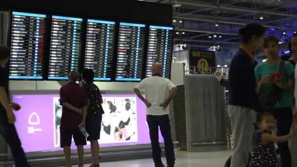 Mensen in de buurt van informatiebord in luchthaven — Stockvideo