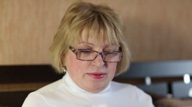 Smartphone ile gözlüklü kadın kıdemli konuşuyor