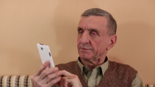 스마트 폰을 가진 노인이 말합니다. — 비디오
