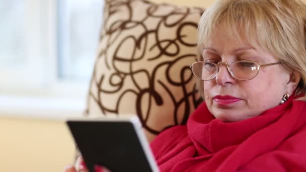 Старшая женщина с помощью электронной книги — стоковое видео