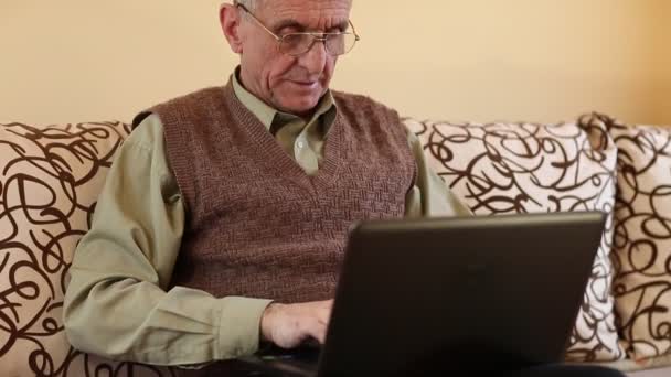 Senior man types using laptop — Stock Video