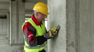 Worker with putty knife at construction site