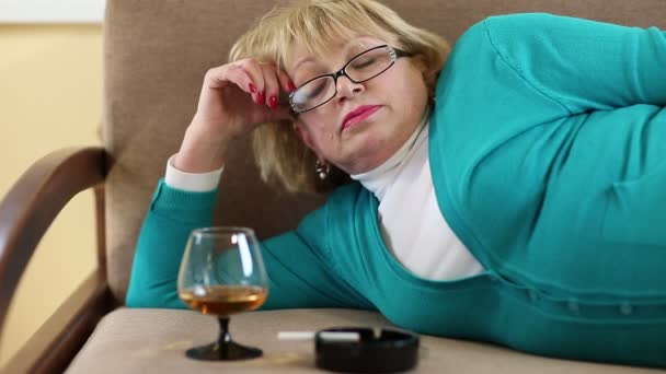 Deprimida mujer mayor bebiendo brandy — Vídeos de Stock