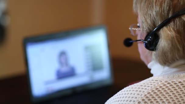 Woman with headphones on computer talks — Stock Video