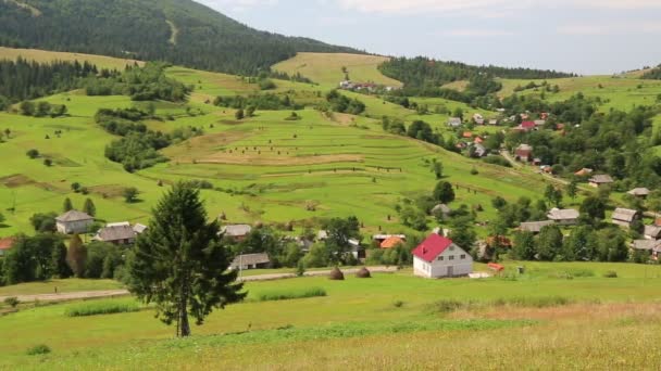 Schöne grüne Hügel und Ferienhaus im Dorf — Stockvideo