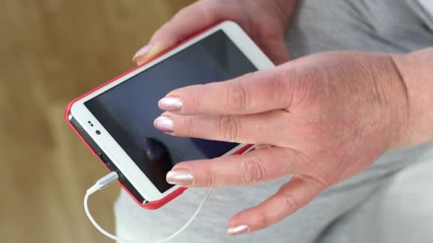 Vrouw op zoek naar foto's in haar smartphone — Stockvideo