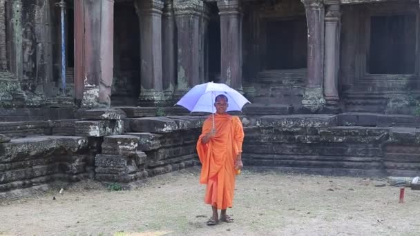 Буддийский монах с голубым зонтиком — стоковое видео